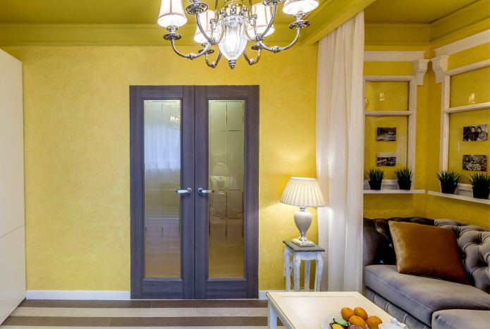 сочетание желтых стен с темно-коричневой дверью со стеклянными вставками