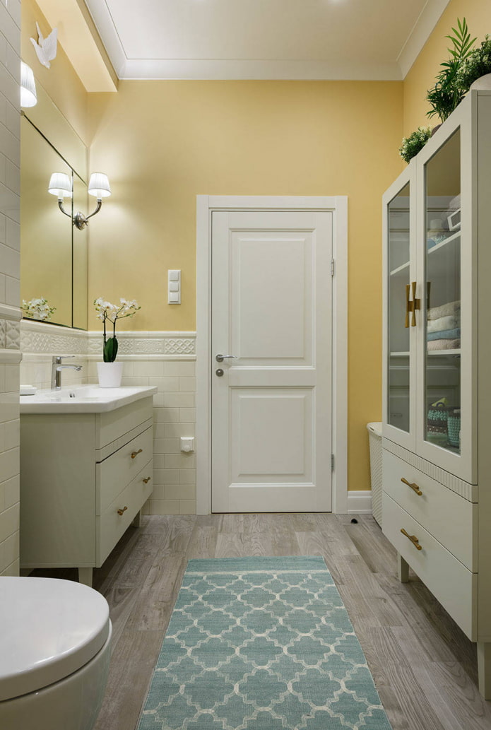 ванная комната с бледно-желтыми стенами и белой мебелью