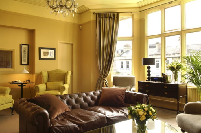 темно-желтая гостиная с коричневым кожаным диваном
