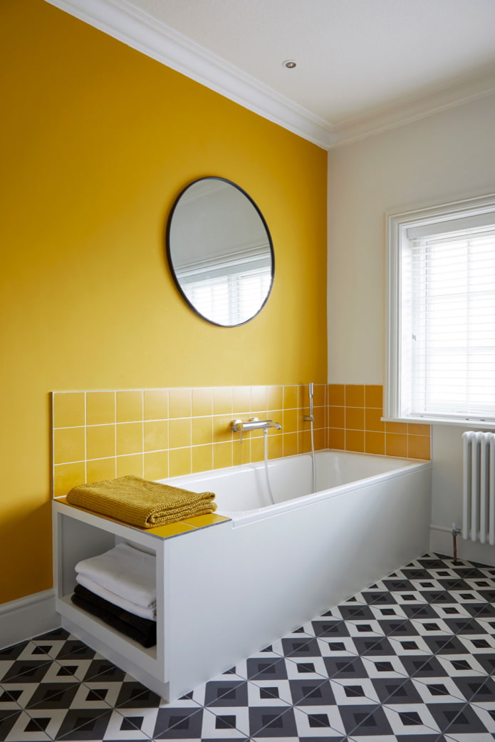 ванная комната с желтой стеной и черно-белым мозаичным полом